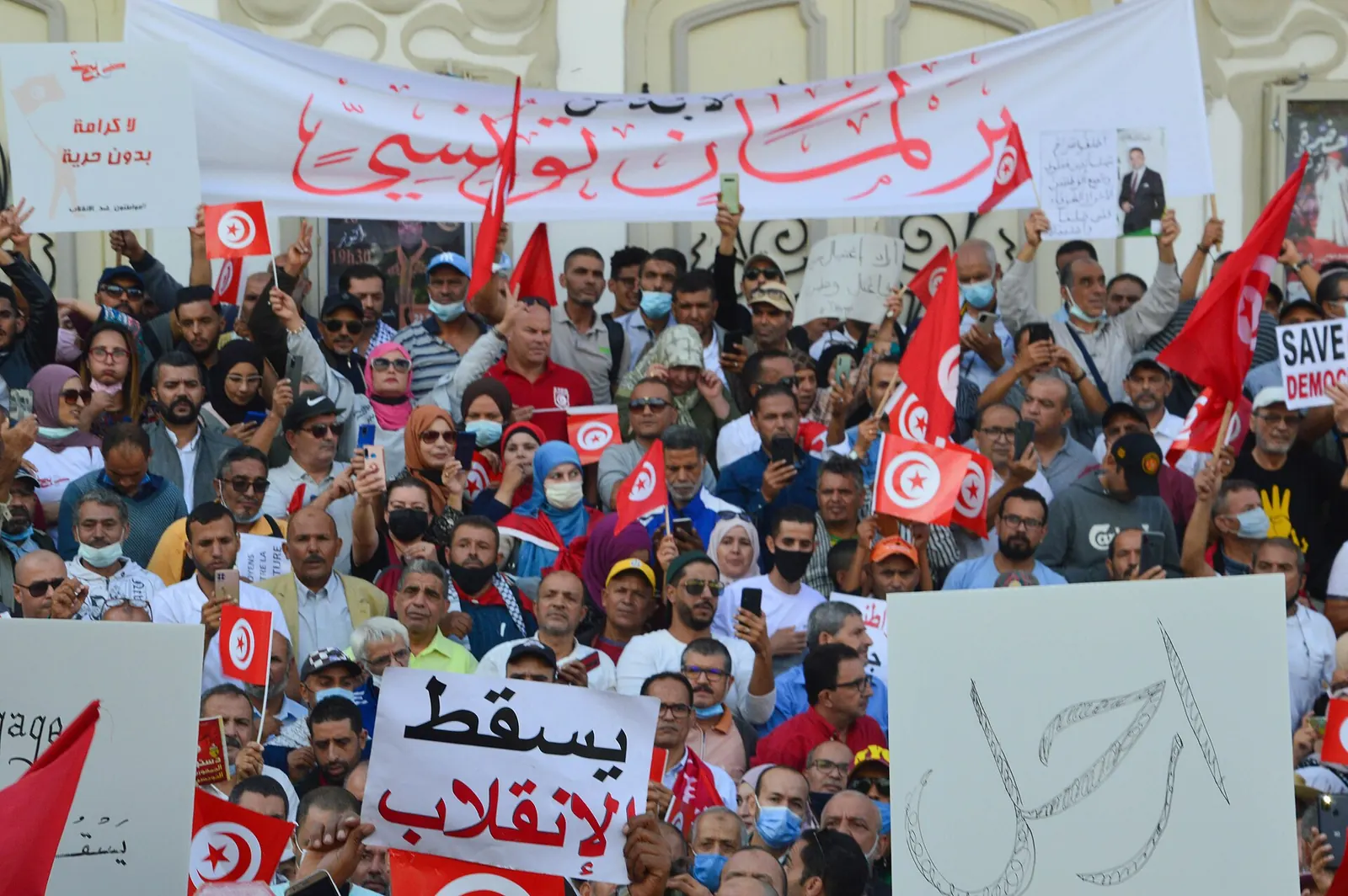 Foule manifestant contre Kais Saied sur l’avenue Habib-Bourguiba, à Tunis, avec les pancartes « À bas le coup d’État » et « Dégage », le 10 octobre 2021
