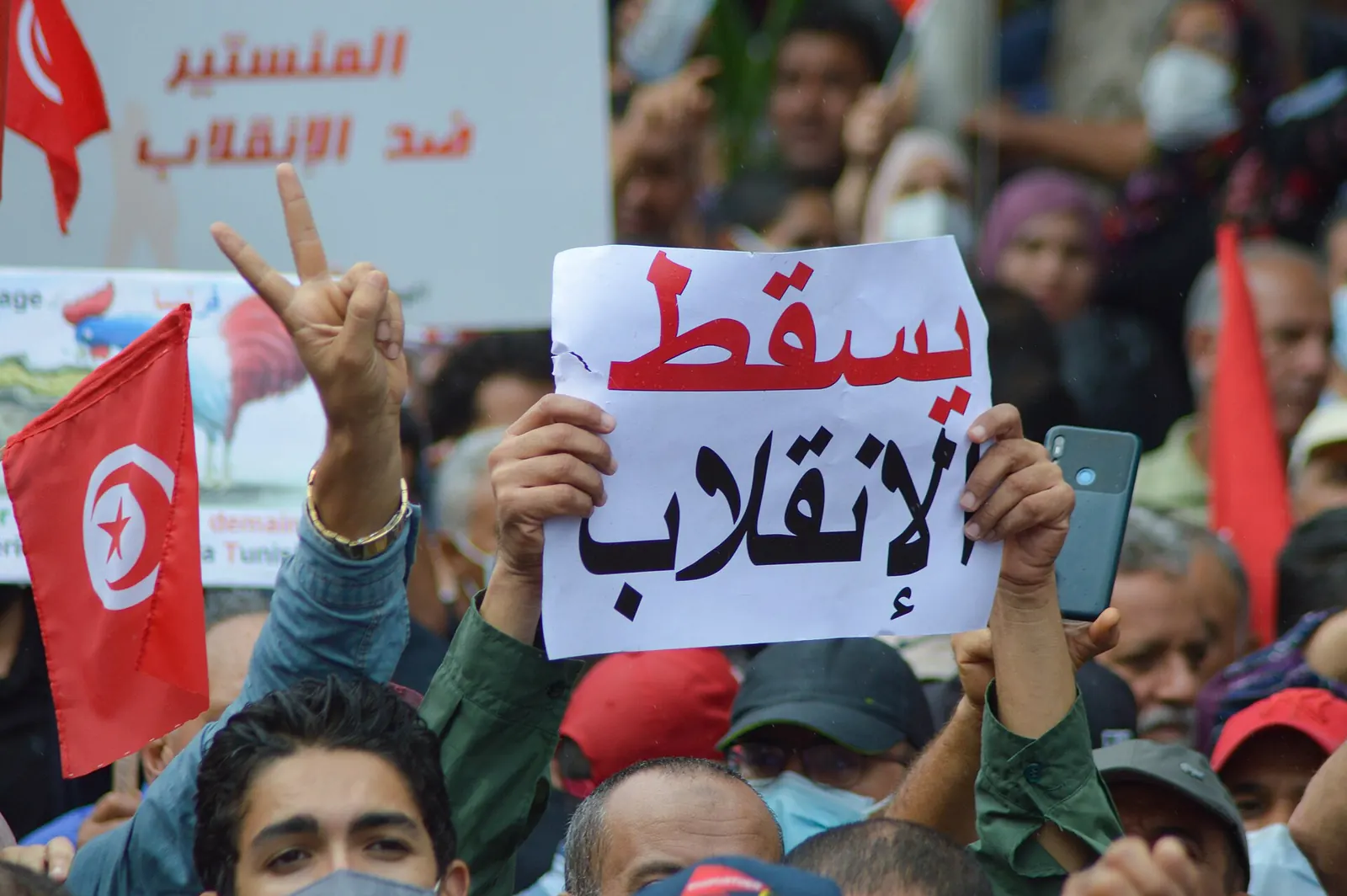 Manifestant tenant une pancarte « À bas le coup d’État » en arabe lors d’une manifestation contre Kais Saied à Tunis, le 10 octobre 2021