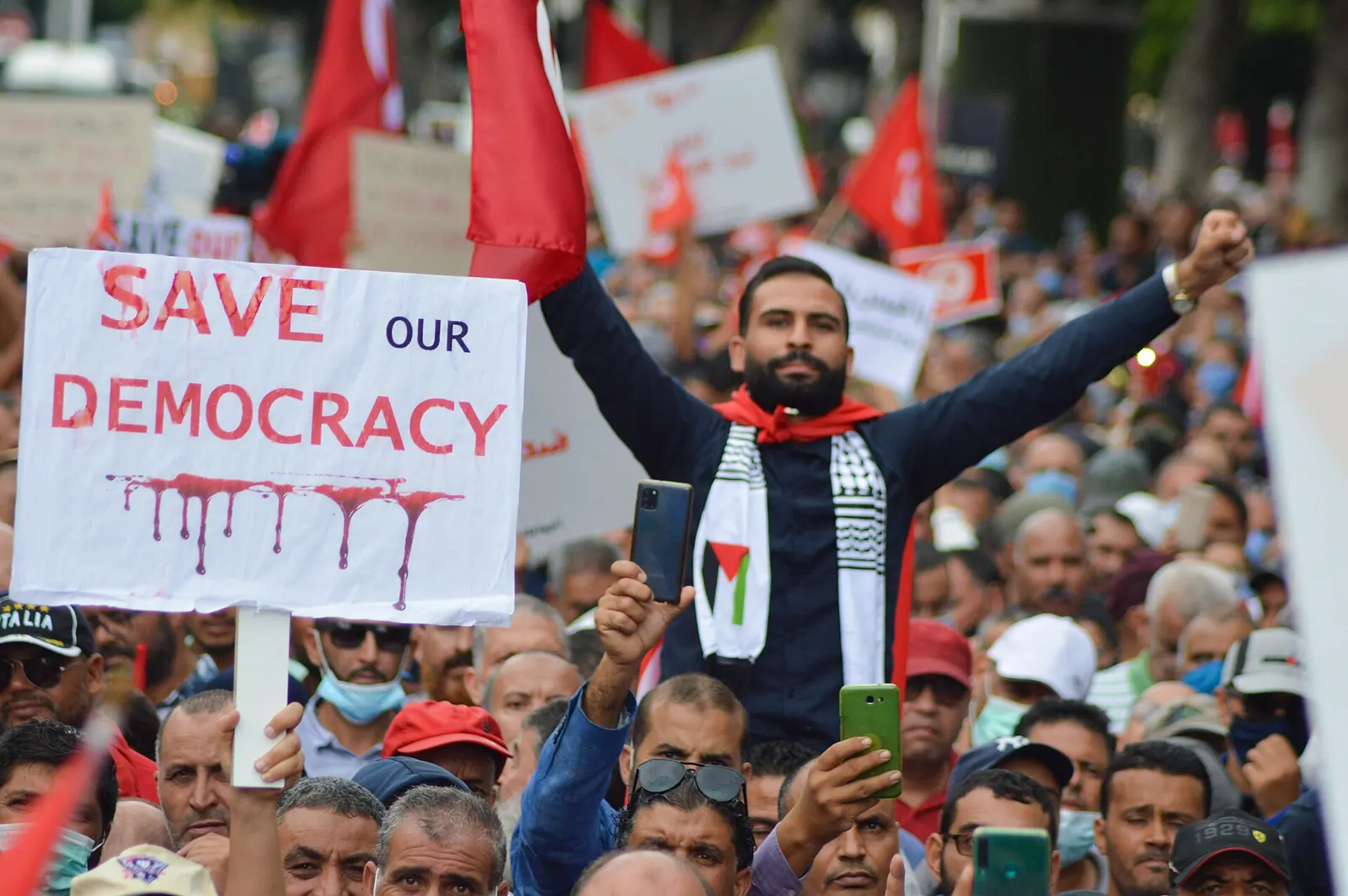 Manifestant brandissant une pancarte « Save our democracy » lors d’une manifestation contre Kais Saied à Tunis, le 10 octobre 2021