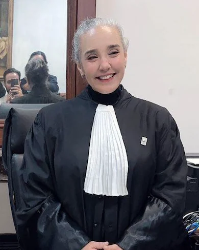 Sonia Dahmani souriante, dans sa robe d’avocate, à son bureau de Tunis le 28 novembre 2025, au lendemain de sa sortie de prison